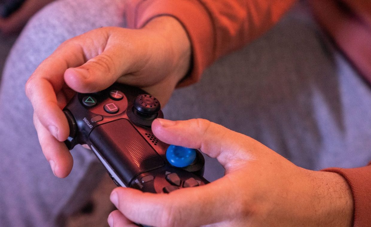 Hands gripping a game controller, showcasing intense gaming focus.