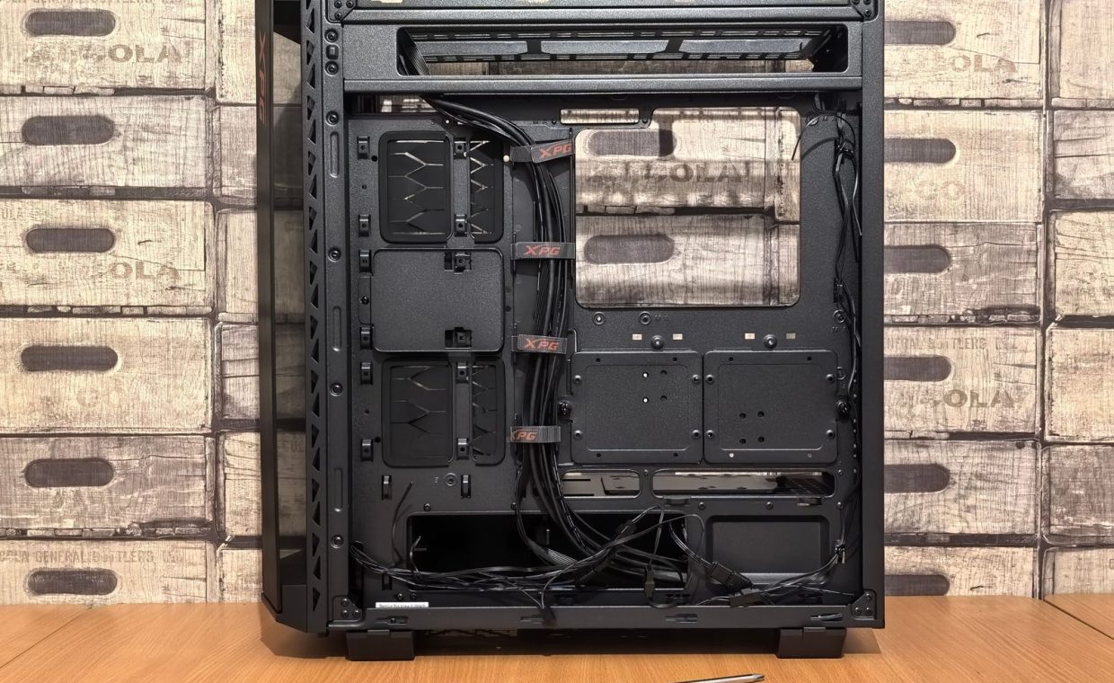 Open computer case ready for installation, with screwdriver placed nearby on desk.