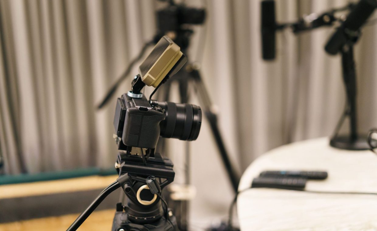 Close-up of a camera and microphone in a professional podcast studio, highlighting equipment setup.