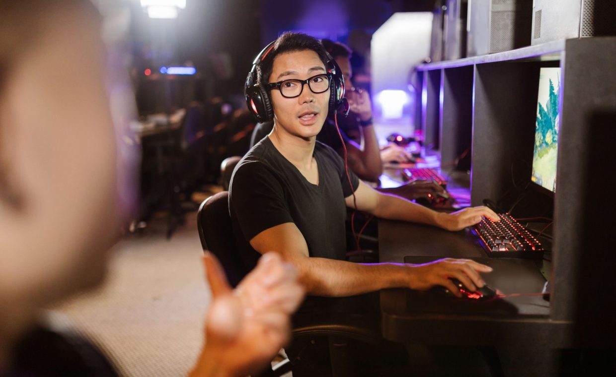 Adult men engaged in competitive video gaming at a modern arcade setting.