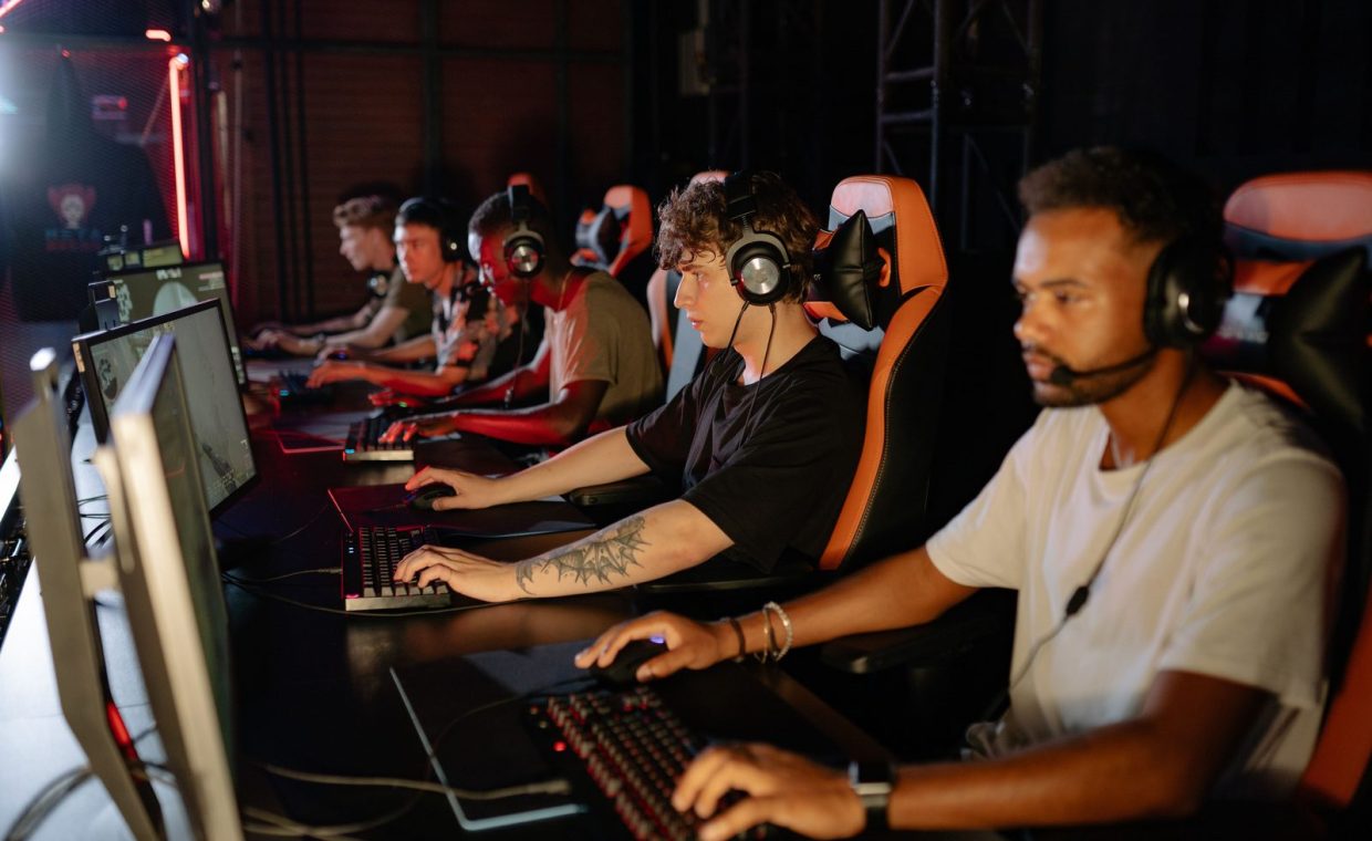 A group of focused young gamers playing in an intense esports tournament indoors.
