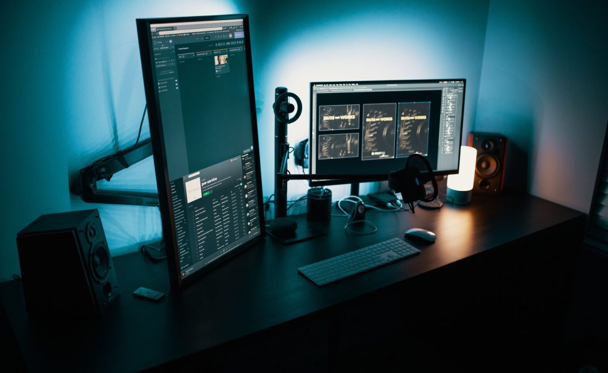 A contemporary office desk featuring a dual monitor setup with stylish lighting, ideal for tech enthusiasts.